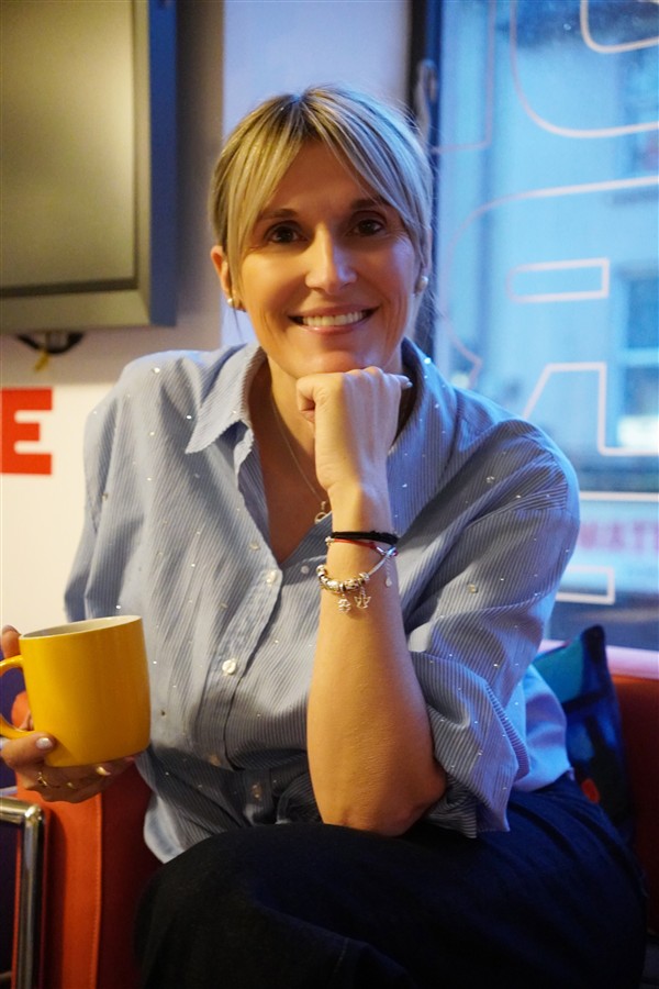 Renata Tupek-Sienicka uśmiechnięta, z kubkiem w dłoni